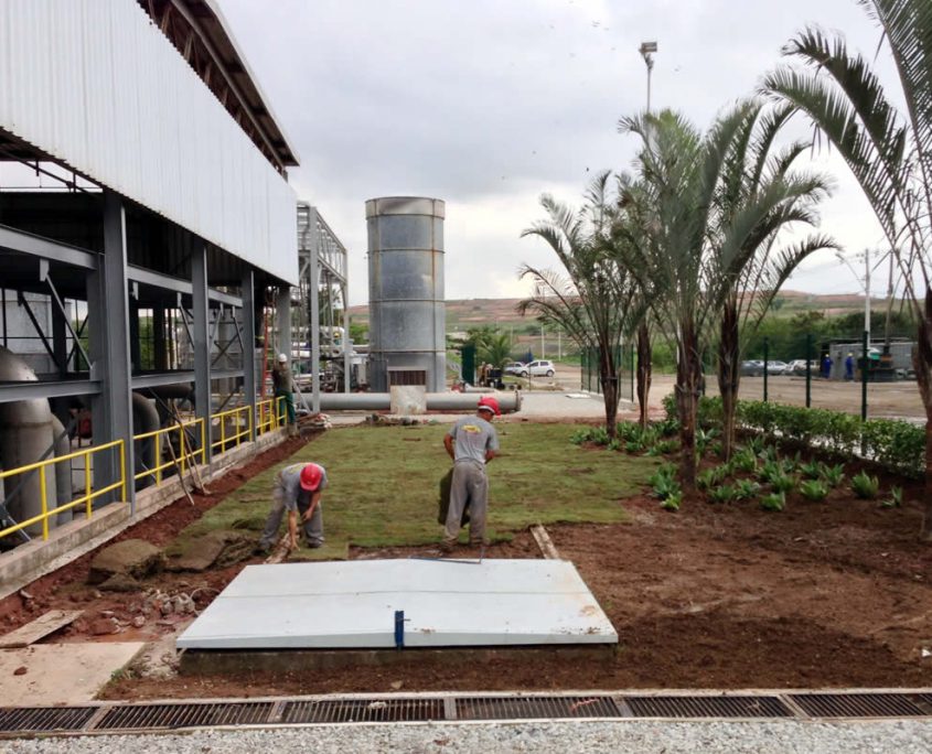 A landscaping crew puts the finishing touches on a biogas processing plant ready to become operational.