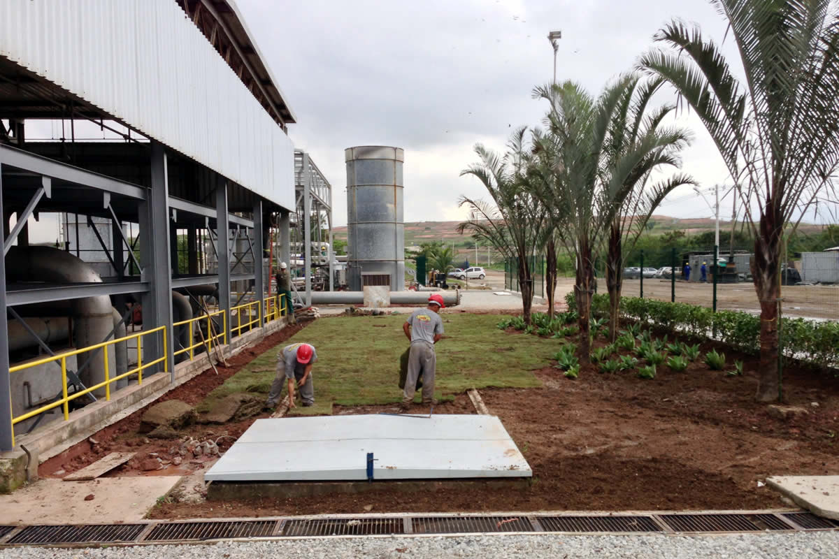 A landscaping crew puts the finishing touches on a biogas processing plant ready to become operational.